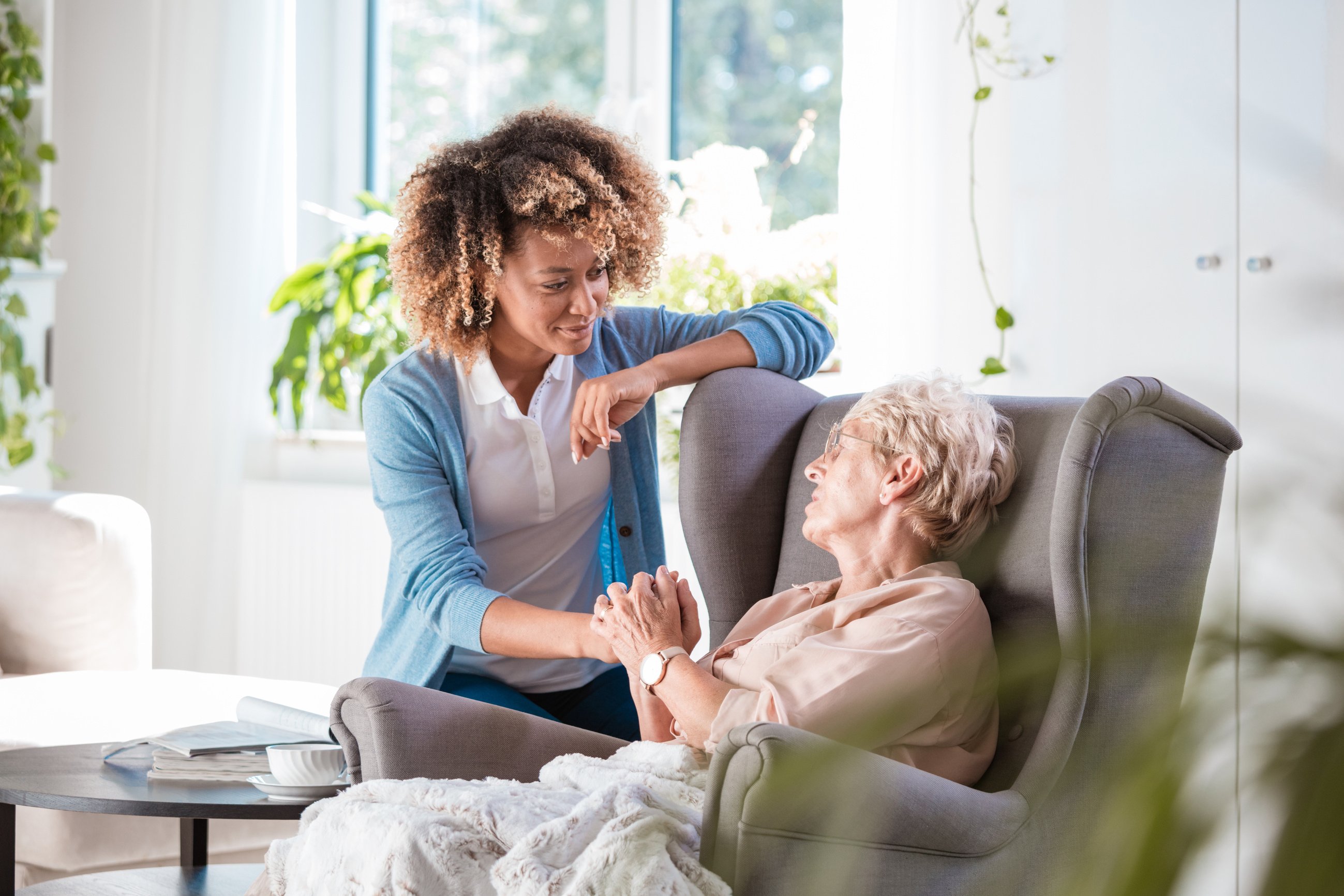 Caring nurse consoling an elderly lady